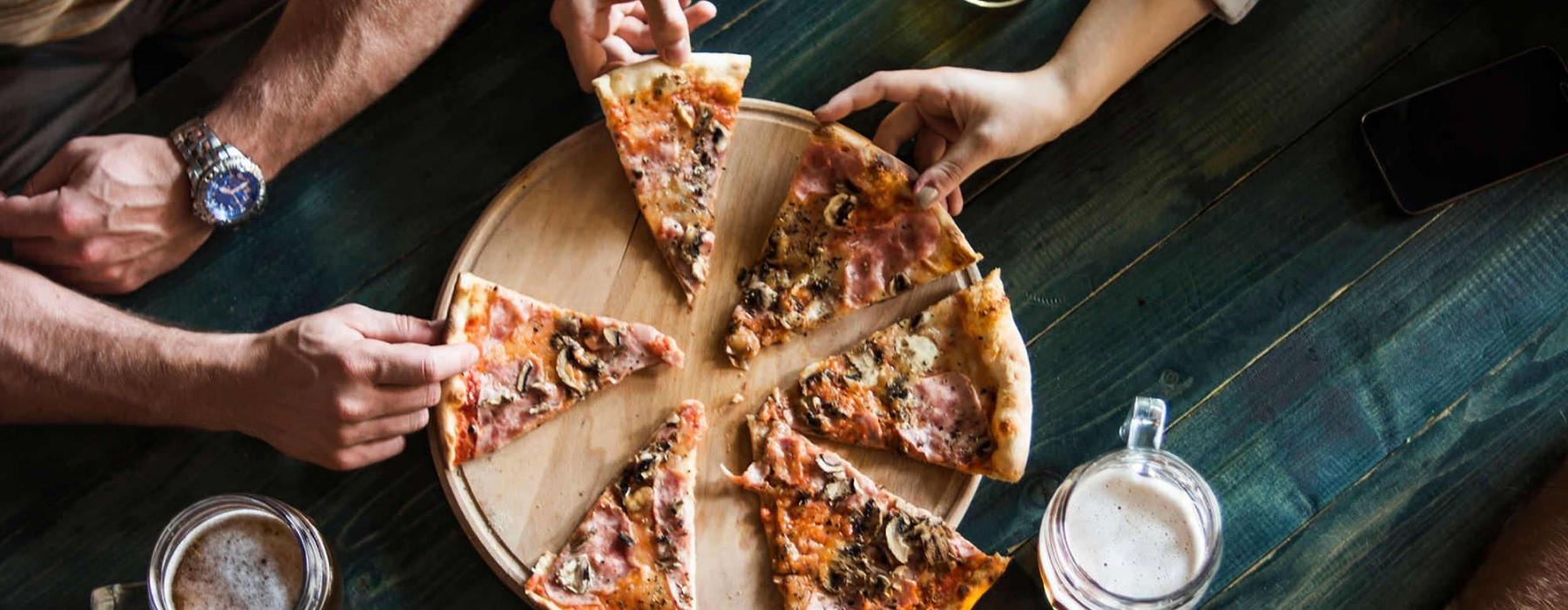 a group of people eating pizza